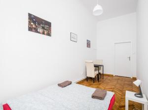 een witte kamer met een bed en een bureau. bij Wąsik in Krakau