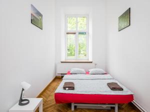 een witte kamer met een bed en een raam bij Wąsik in Krakau