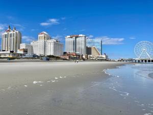 a view of a beach with hotels and a ferris wheel at 3 Bedrooms, Boardwalk Duplex Beachblock Home! in Atlantic City