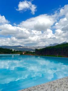 ein großer Pool mit blauem Wasser und Bäumen im Hintergrund in der Unterkunft Cerdeirinhas de basto Hospedagem in Canedo de Basto