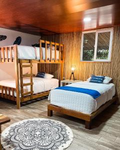 a bedroom with two bunk beds and a window at Hotel Tortuga Village in La Herradura