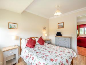 una camera da letto con un letto con cuscini rossi di Orchard Cottage a Saint Osyth
