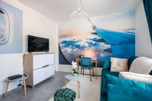 un soggiorno con divano blu e un dipinto di In the Sky - Casa Vostra - CAUTION 800 EUR & ID requises - Ambilly proche tramway-frontière ad Ambilly Altre 12 foto
