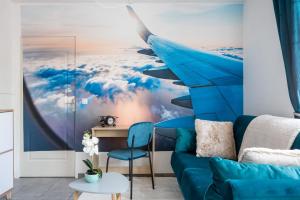un murale di un aeroplano in un soggiorno con un divano blu di In the Sky - Casa Vostra - CAUTION 800 EUR & ID requises - Ambilly proche tramway-frontière ad Ambilly