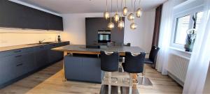 a kitchen with a large island with black cabinets at Blumen(t)raum Ferienwohnung 2 in Karlsruhe