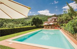 uma piscina com um guarda-sol ao lado de uma casa em Casa Vanessa em Cireglio