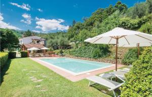 a swimming pool with an umbrella and two lawn chairs and an umbrella at Casa Vanessa in Cireglio
