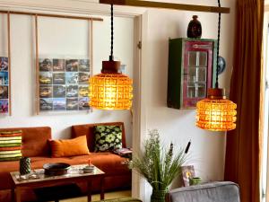 sala de estar con sofá y 3 luces colgantes en 2 værelses retro lejlighed på Torvet, en Horsens
