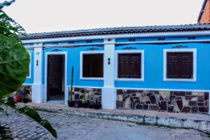 a blue house with two windows and a door at Buena Vibe Hostel in Lençóis