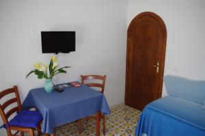 a room with a table and chairs and a tv at Casa Fortunata in Positano
