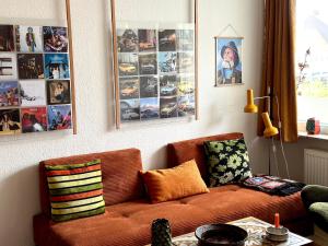 a living room with a couch and pictures on the wall at 2 værelses retro lejlighed på Torvet in Horsens