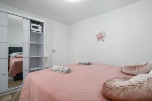 a bedroom with a large bed with a pink blanket at Apartment Ivana in Malinska +7 photos