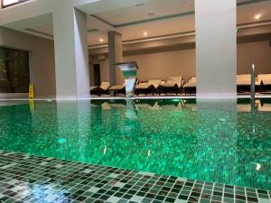 a swimming pool with green water in a building at Pano Kopaonik Panorama in Kopaonik