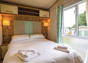 a bedroom with a large bed with towels on it at Parc Farm Holiday Park in Mold
