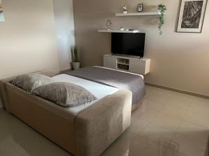 a bedroom with a bed and a flat screen tv at Apartmani Nina i Niko in Ugljan