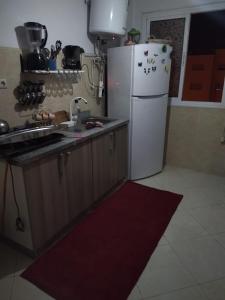 a kitchen with a white refrigerator and a sink at Repose toi c comme chez soi in Oujda