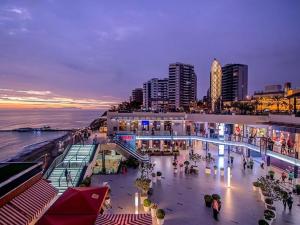 una vista de la ciudad por la noche con personas y edificios en The Place Miraflores, en Lima