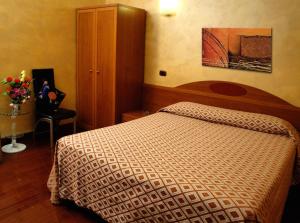 a bedroom with a bed and a cabinet and flowers at Hotel Bengasi in Moncalieri