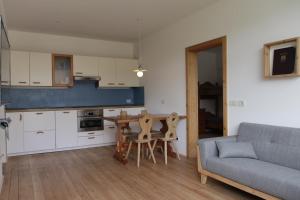 cocina y sala de estar con mesa y sofá en Rasterhof, en Aldino