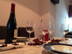 einen Tisch mit einer Flasche Wein und drei Weingläsern in der Unterkunft Bohemian Rhapsody NBG in Belgrad