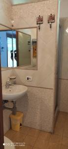 y baño con lavabo y espejo. en La Piana di Alsium, en Ladispoli