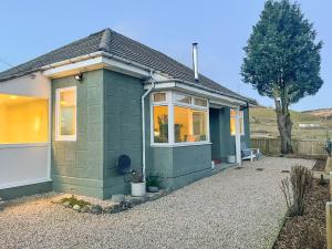 a small green house in a gravel yard at Mossdale Cottage in Dalmellington