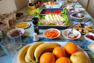una mesa con naranjas de plátano y otros alimentos. en Willa DanSar en Rewal