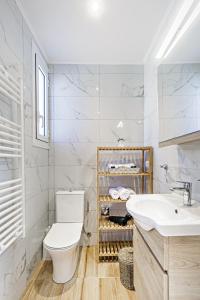 uma casa de banho branca com um WC e um lavatório em Ionian Citizen Penthouse em Corfu Town