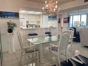 クリアウォーター・ビーチにある440 West Condo 1602N Sensational Gulf-viewのダイニングルーム、キッチン(ガラスのテーブル、椅子付)