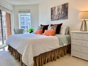 a bedroom with a large bed with orange pillows at Belle Harbor 803-M - Panoramic Views in Clearwater Beach