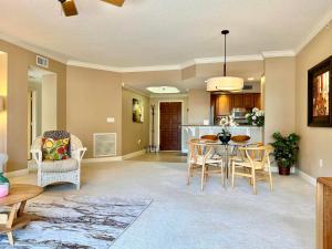 a living room with a table and chairs and a kitchen at Belle Harbor 803-M - Panoramic Views in Clearwater Beach