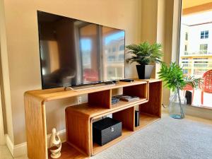 a flat screen tv on a wooden entertainment center at Belle Harbor 803-M - Panoramic Views in Clearwater Beach