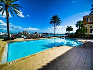 una piscina con palme e acqua di Belle Harbor 310W Luxury Condo with Oversized Balcony a Clearwater Beach