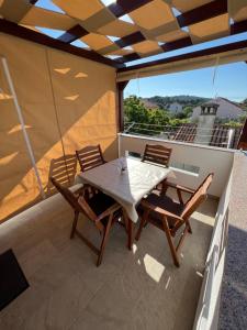 a wooden table and chairs on a balcony at Apartmani Nina i Niko in Ugljan