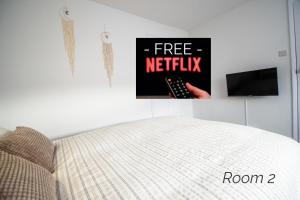 a bed with a free netflix sign on a wall at Town House Chantry - With Self Check In and Free Parking - Rooms at ipswichdigs in Ipswich