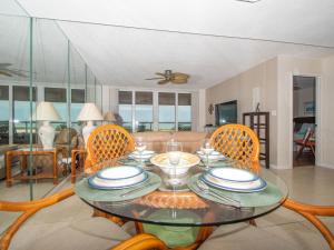 a dining room with a glass table and chairs at Crescent Beach Club 3B Beachfront Views of the Gulf in Clearwater Beach