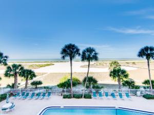 a swimming pool with palm trees and a beach at Harbour Light Towers 307 3rd Floor Beachfront 2 Bedroom Harbour Light Towers in Clearwater Beach