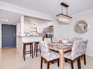 a dining room and kitchen with a wooden table and chairs at Harbour Light Towers 307 3rd Floor Beachfront 2 Bedroom Harbour Light Towers in Clearwater Beach