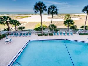 a swimming pool with palm trees and a beach at Harbour Light Towers 307 3rd Floor Beachfront 2 Bedroom Harbour Light Towers in Clearwater Beach