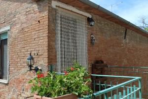 a brick building with a large window with plants at Casa vacanza Podere Ristoro in San Giovanni dʼAsso