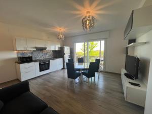eine Küche und ein Wohnzimmer mit Tisch und Stühlen in der Unterkunft Scaramuzza 7 in Grado