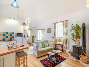 a kitchen and living room with a couch and a table at The Byre in Eggleston