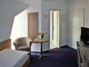 um quarto de hotel com uma cama e uma mesa com uma cadeira em Hotel Fürstenberg em Eisenhüttenstadt