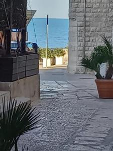 a stone walkway with a view of the ocean at Suite Duomo Trani 8 in Trani