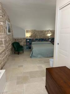 a bedroom with a green bed and a stone wall at Suite Duomo Trani 8 in Trani