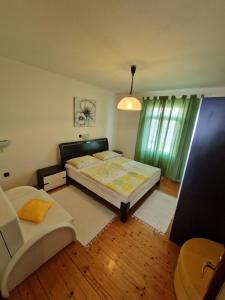 a bedroom with a bed and a chair in it at Villa Cvetić in Selce