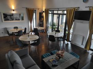 a living room with tables and chairs and a couch at Pensiunea Freya in Colibiţa