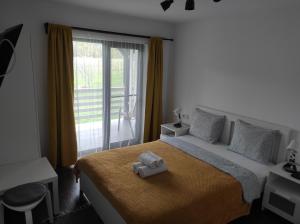 a bedroom with a bed with a towel on it at Pensiunea Freya in Colibiţa