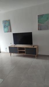 een woonkamer met een flatscreen-tv op een kast bij Yona balev in Eilat
