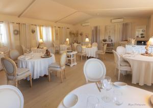 un comedor con mesas y sillas blancas en Guesthouse Le Mas de Cotignac, en Cotignac